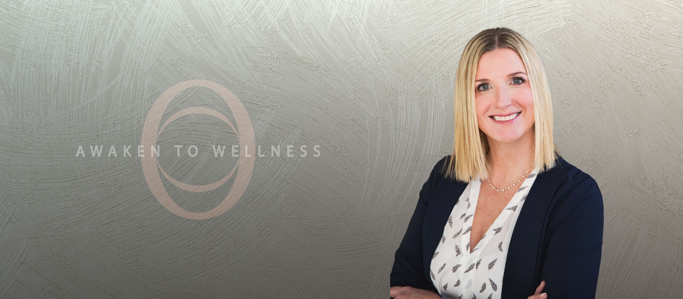 Smiling med spa and concierge medicine staff member in front of a wall