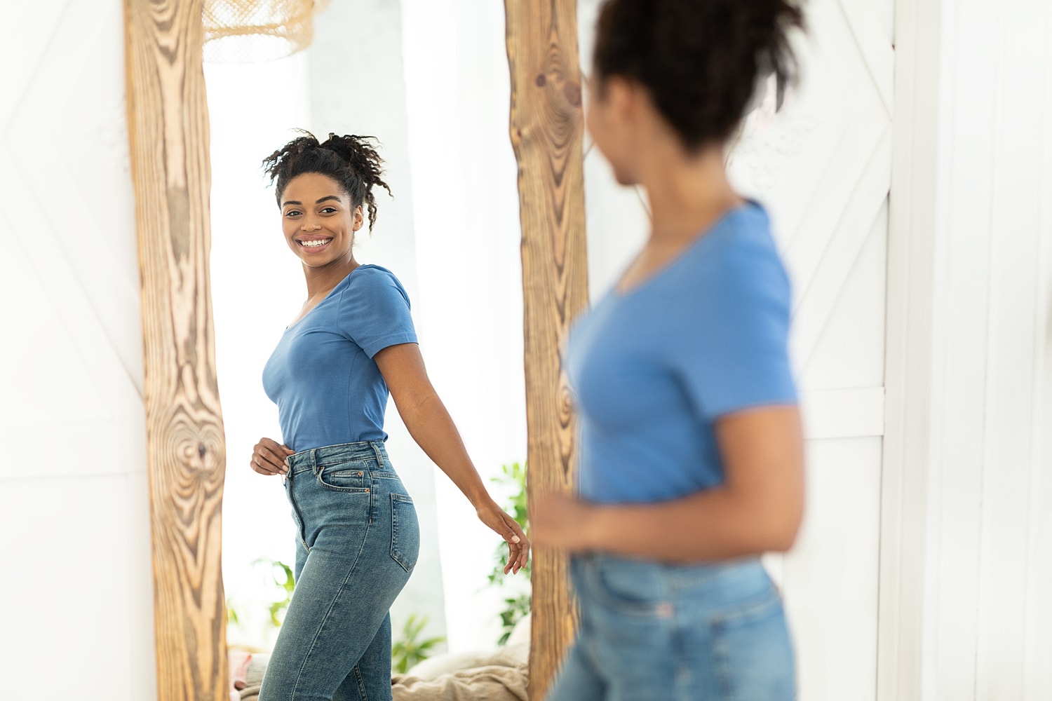 Woman smiling at her reflection in a mirror.